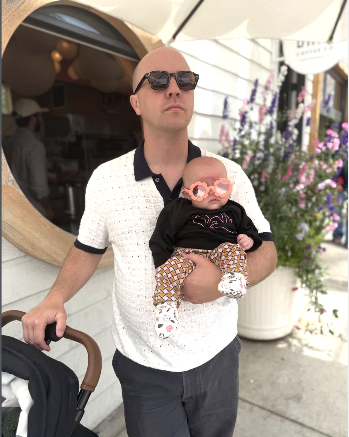 Eric Jorgensen holding his daughter, both in sunglasses